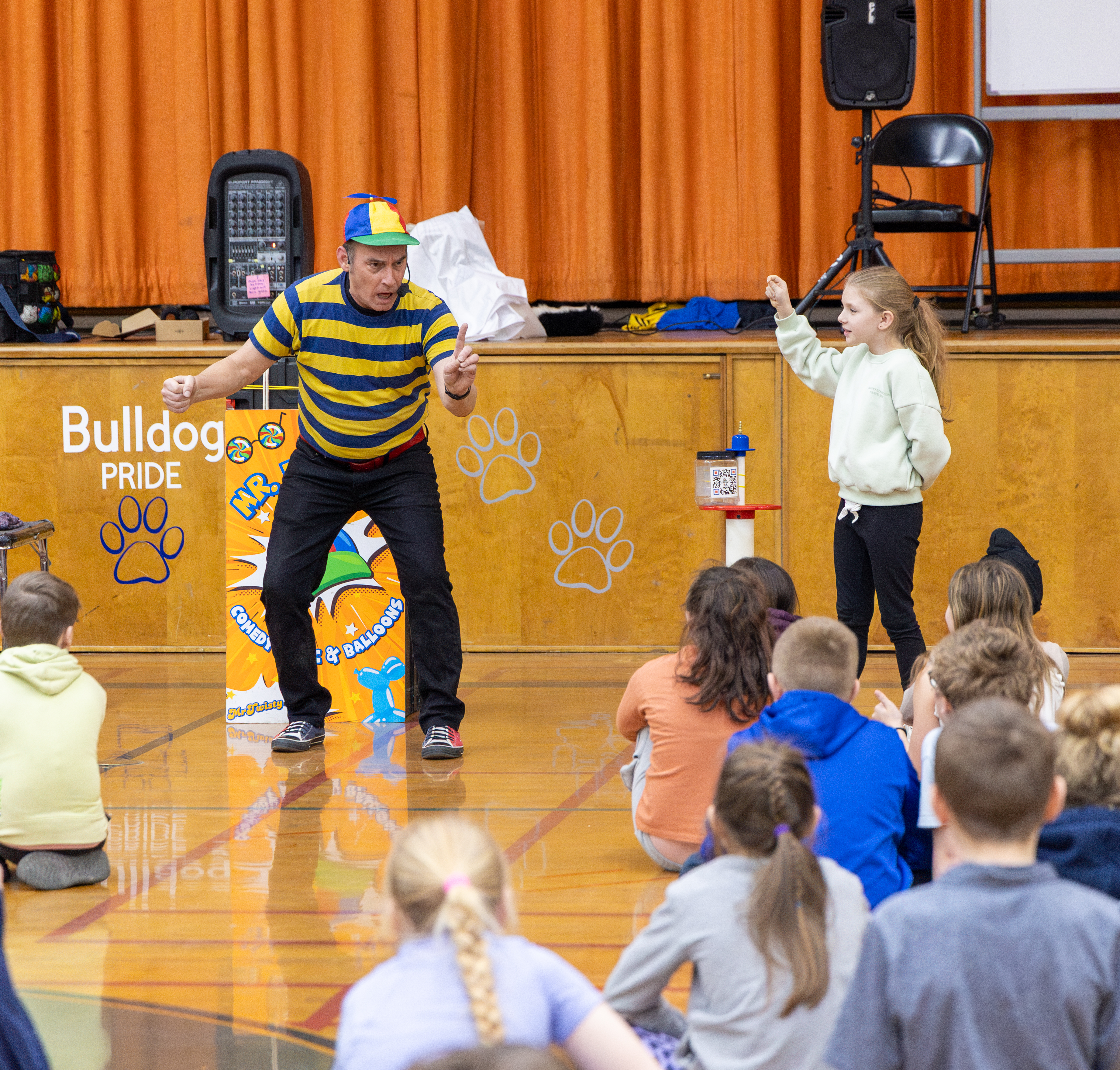 A student volunteer on stage with Mr. Twisty