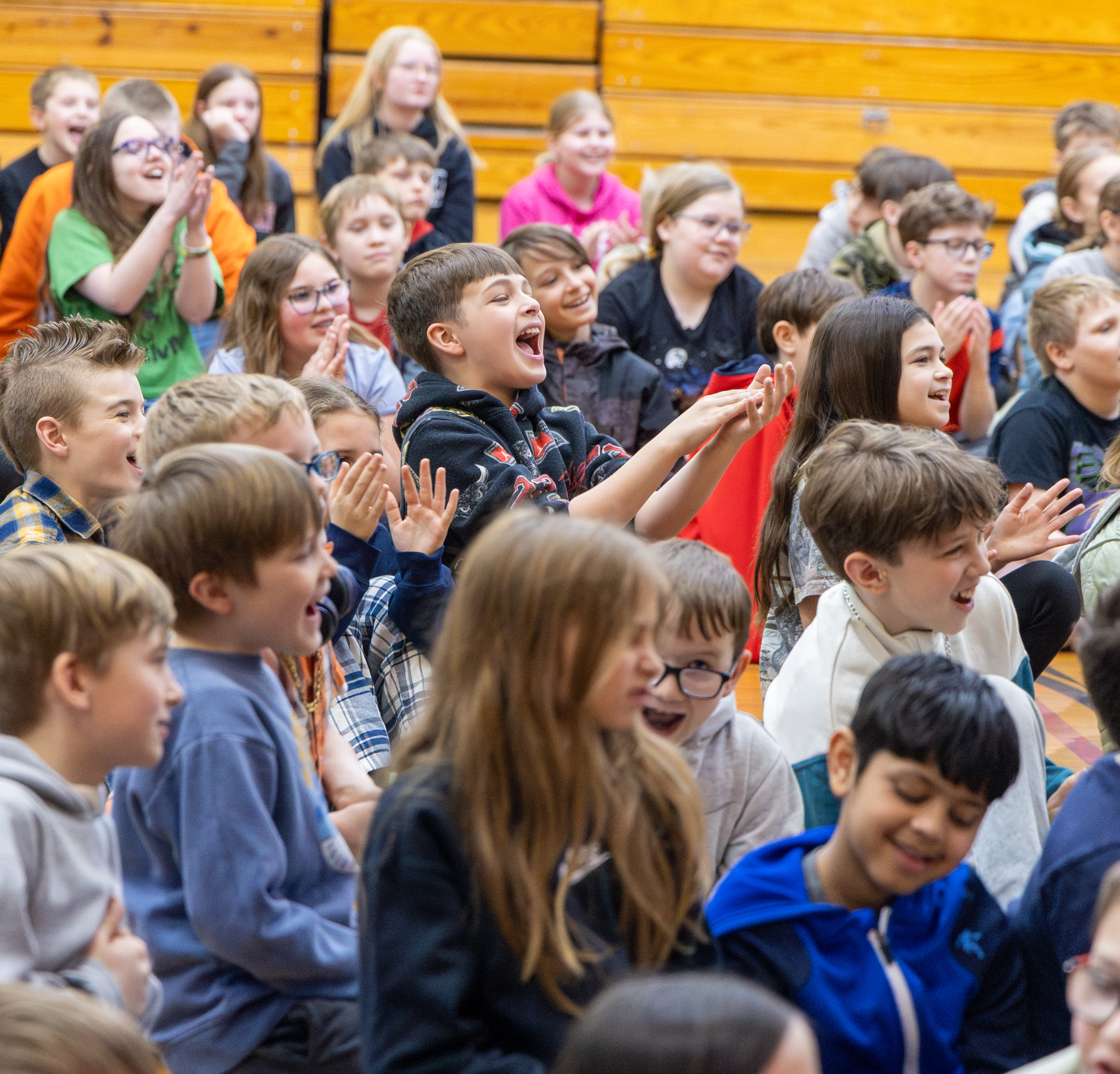 Students clapping and cheering with hands up