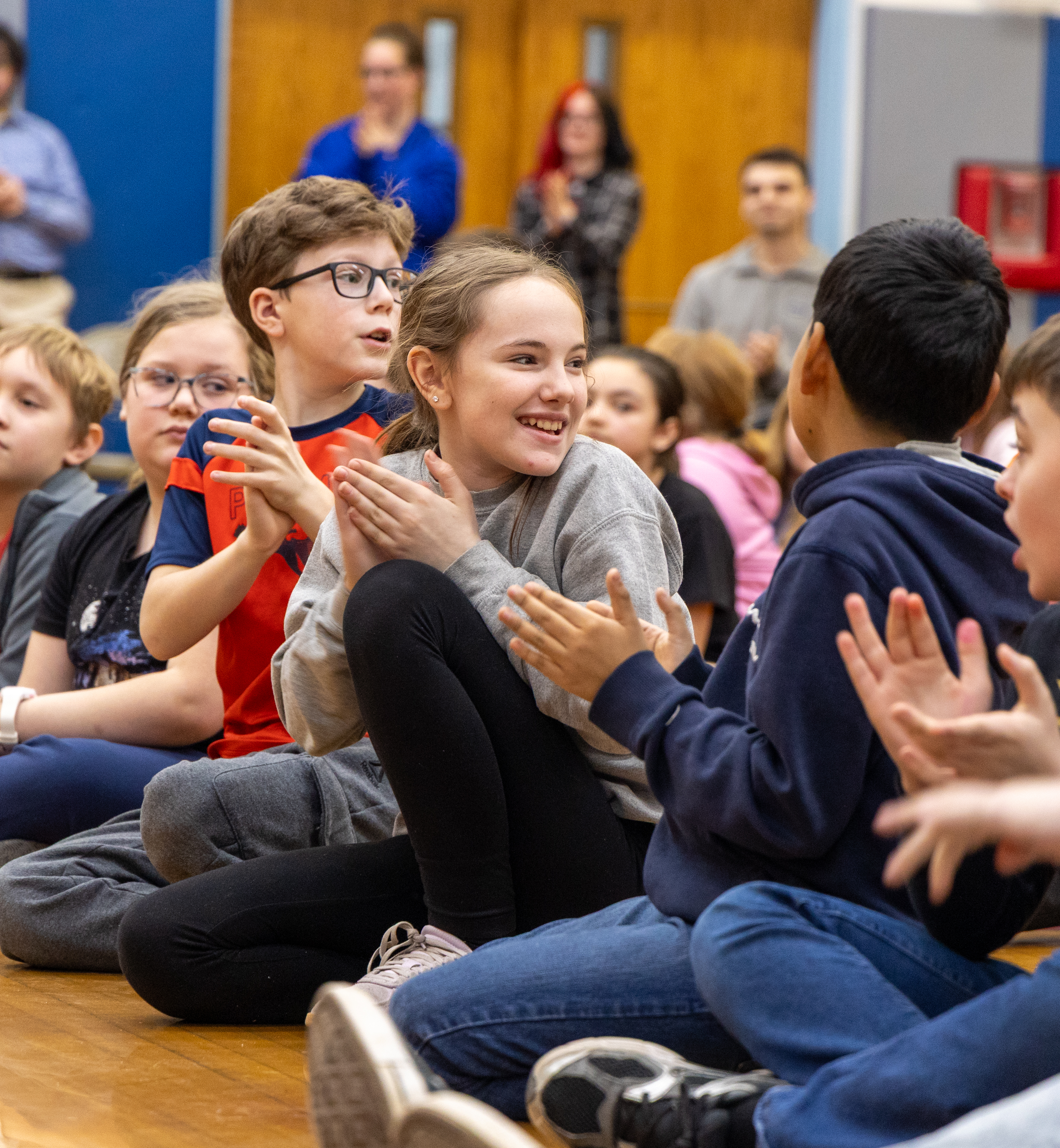 A young student smiling and clapping