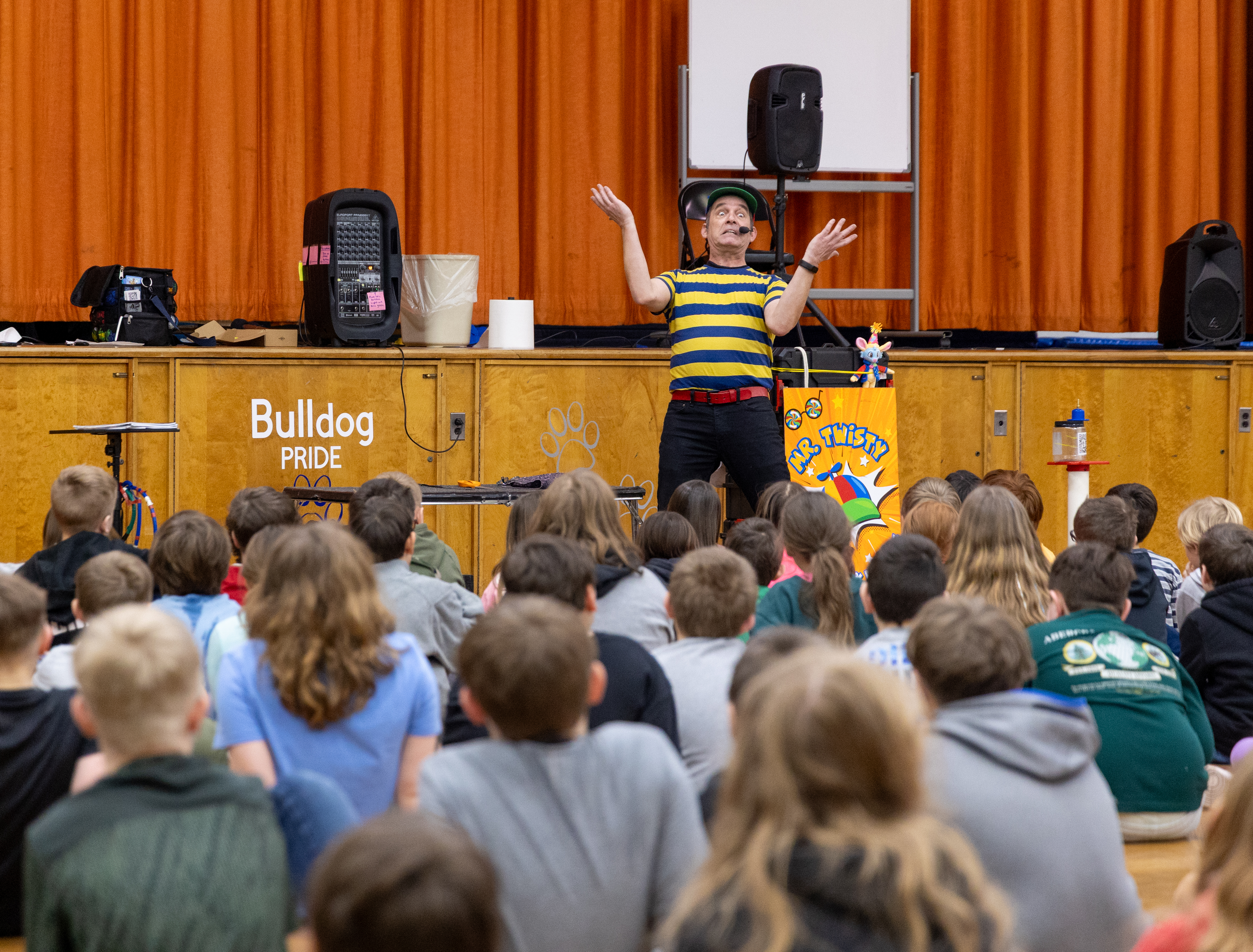 Mr. Twisty with arms raised before a big audience